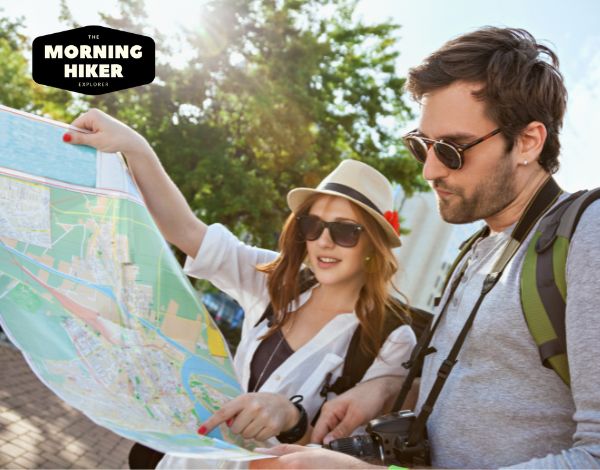 Couple looking at map while planning a city backpacking trip